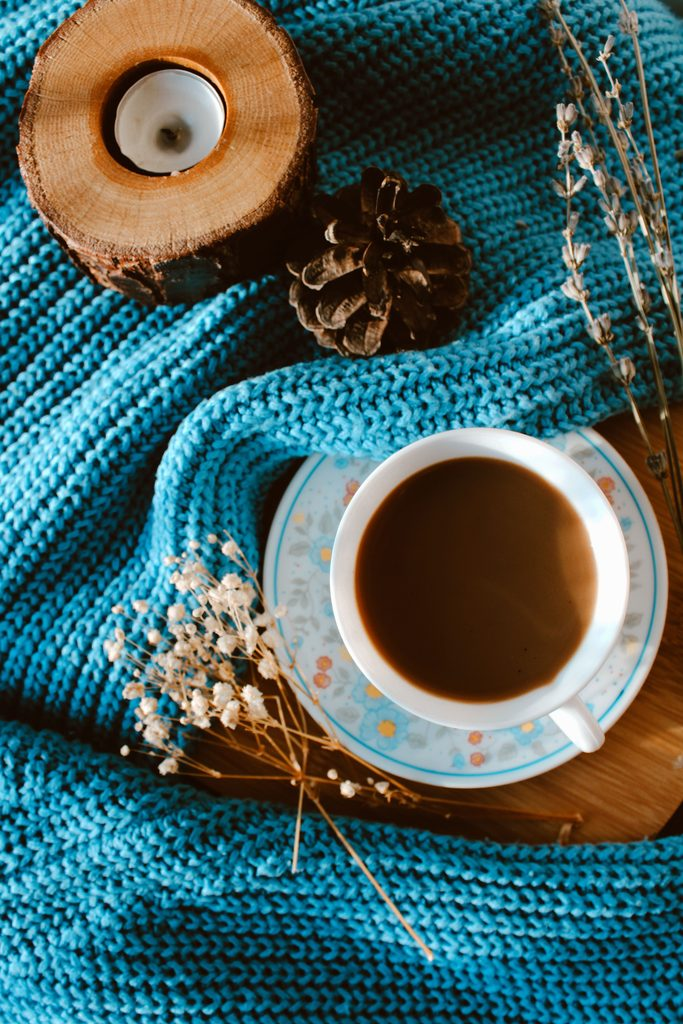 cozy coffee cup with knit blanket, candle, and lavender